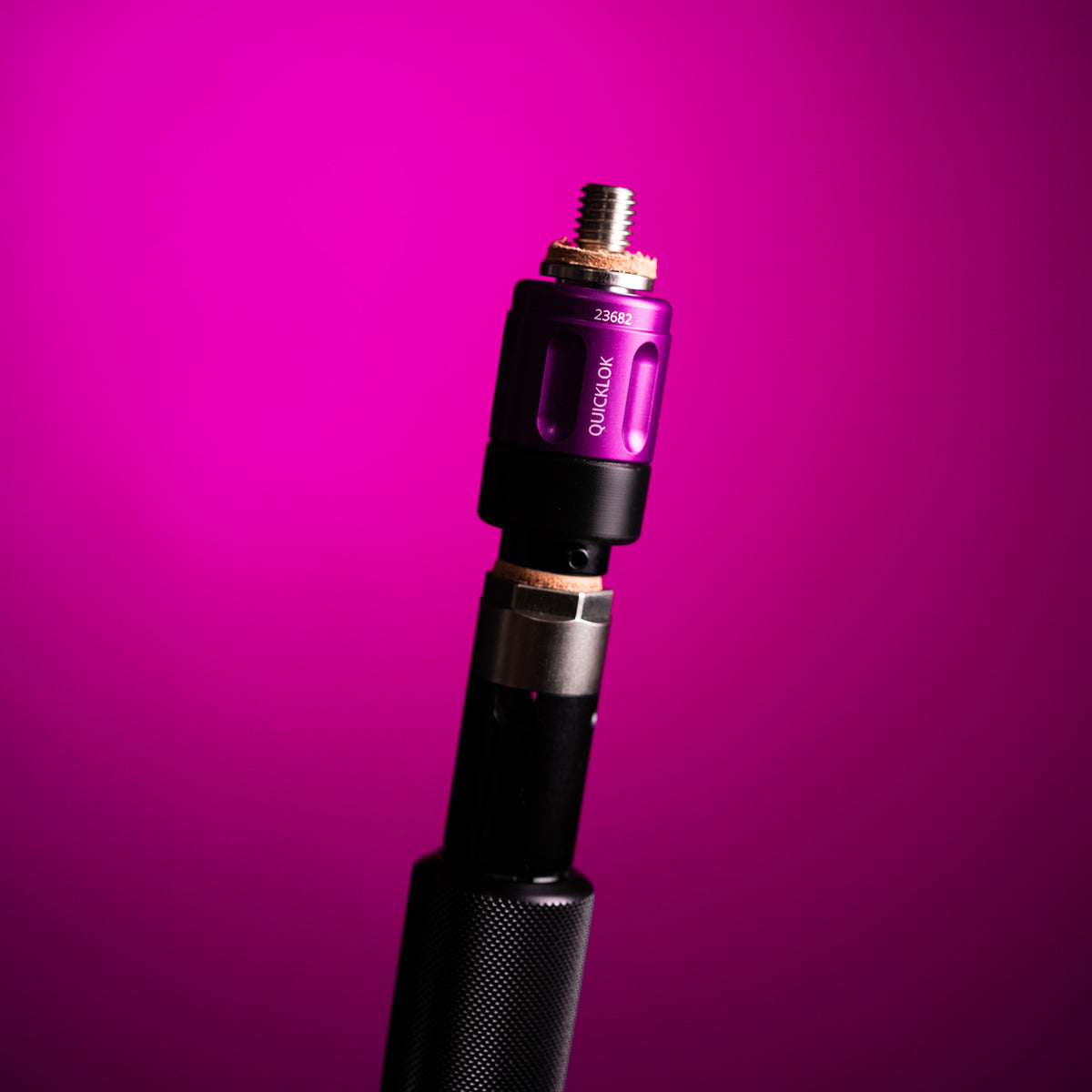 QuickLok in purple mounted on a boom pole, with the tip inserted, against a purple background